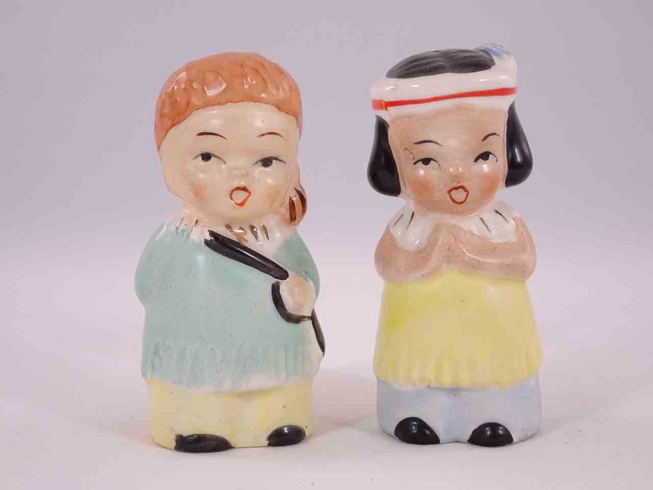 Davy Crockett-like boys carrying guns with little Native American Indian girls salt and pepper shakers