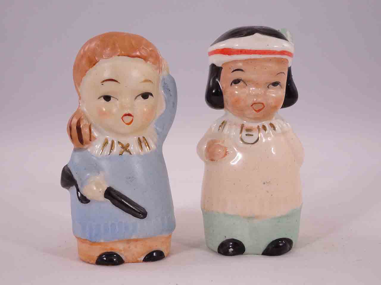 Davy Crockett-like boys carrying guns with little Native American Indian girls salt and pepper shakers