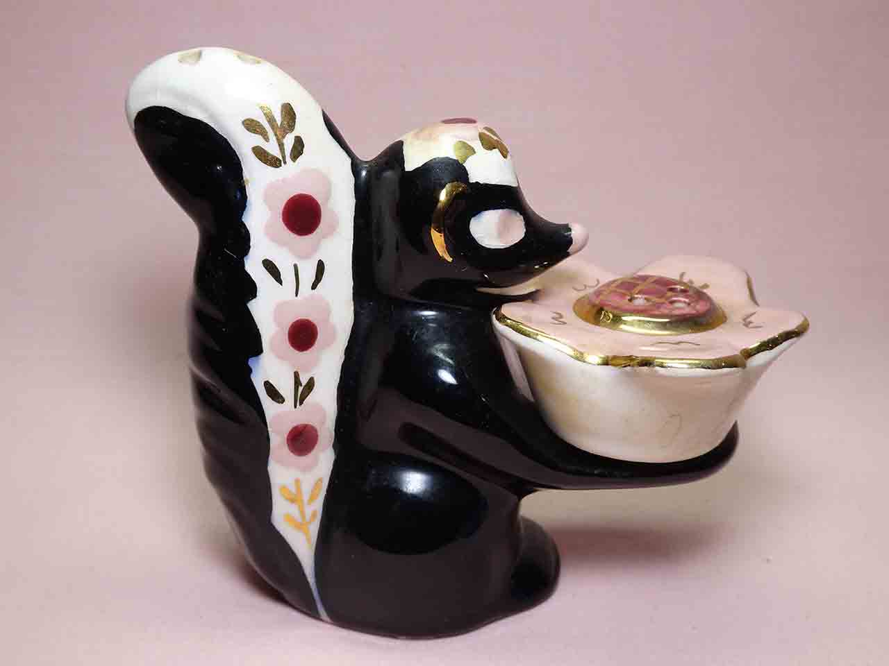 Poinsettia Studios California salt and pepper shakers - skunk holding flower